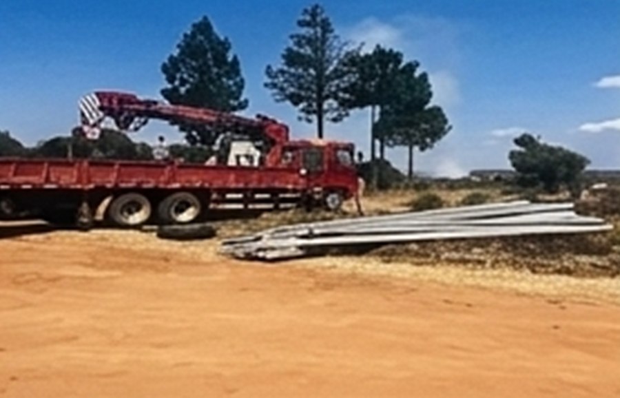 Utility poles and a crane truck at a pole stockpile